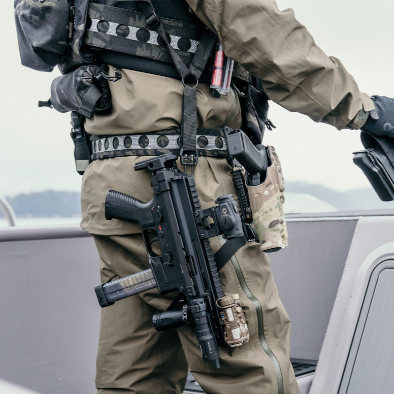 Photo showing the Ferro Concepts Single Point Slingster in action during a tactical mission highlighting how the padded single point sling securely retains a sub-gun or PDW while allowing smooth dominant to non-dominant shoulder transitions. The welded steel ring, quick-adjust pull tab, and metal quick release buckle provide rapid access and weapon control in close quarters combat and urban operations